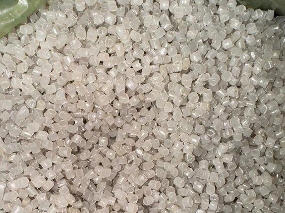Ảnh chụp cận cảnh các hạt nhựa màu trắng đục trước gia công