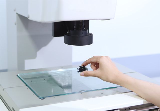 Đặt chi tiết nhựa nhỏ trên bàn kính của thiết bị đo quang học